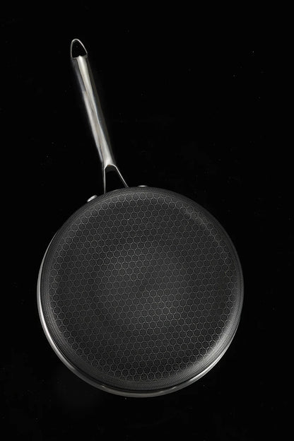 Black frying pan with a textured surface on a black background